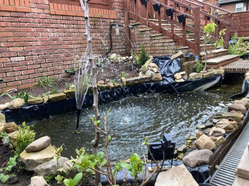 a garden with a pond in a brick wall at B4-Jacks Court in Stalybridge