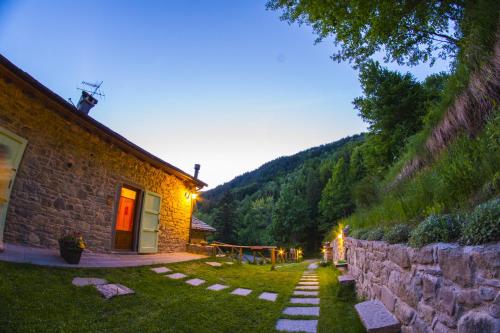 a stone house with a stone wall next to a building at Il Borgo Dei Celti in Fiumalbo