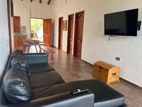 a living room with a leather couch and a flat screen tv at Orquideas 3 in Jericó