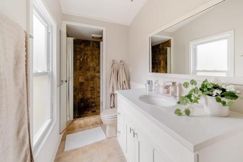 a white bathroom with a sink and a toilet at Modern Cozy Waterfront Cottage with Fireplace in Livingston Manor