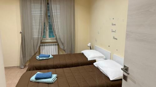2 camas en una habitación pequeña con 2 camas sidx sidx sidx en Casa Gemelli Home en Roma