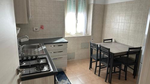 Casa Gemelli Home في روما: مطبخ صغير مع طاولة وكراسي وموقد