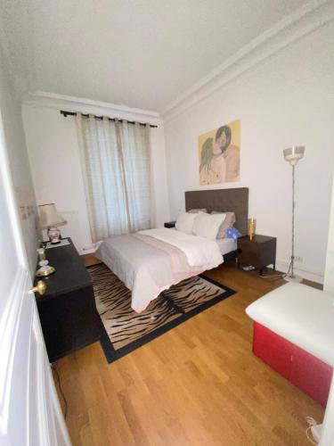 - une chambre blanche avec un lit et une table avec une lampe dans l'établissement Haussmannien moderne 2 pièces quartier Europe du 8éme, à Paris