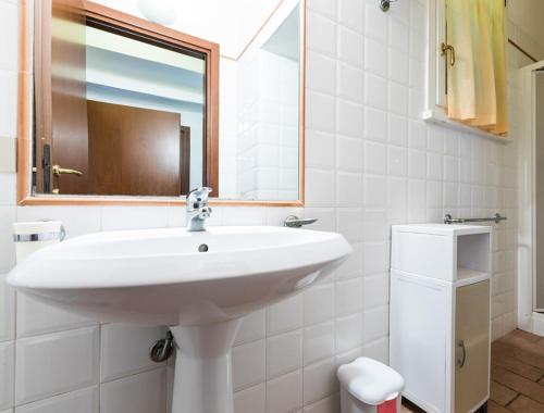 een witte badkamer met een wastafel en een spiegel bij Podere Simonetta - A11 in Cecina
