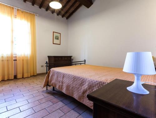 een slaapkamer met een bed en een lamp op een tafel bij Podere Simonetta - A11 in Cecina