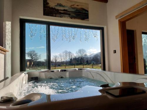 una vasca idromassaggio in un bagno con una grande finestra di Villa D-IKA a Brušane