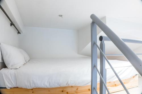 Ce lit se trouve dans un dortoir aux murs blancs. dans l'établissement Suite Standing dans bel Hôtel Particulier, à Dijon