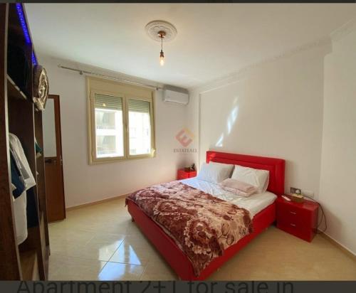 um quarto com uma cama vermelha e uma janela em Seaview em Vlorë