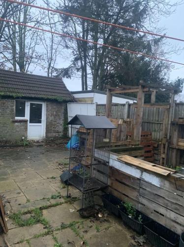 a bird cage in a yard next to a fence at Spacious 1 bedroom en-suite, kitchen and garden space in Ilford
