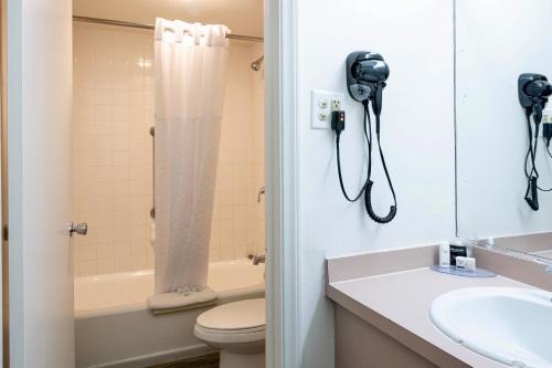 a bathroom with a shower and a toilet and a sink at Ramada by Wyndham Yuma in Yuma