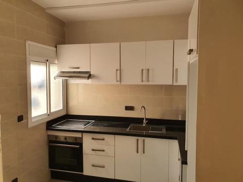 a kitchen with white cabinets and a sink at Mooi appartement, Route el Aounia Oujda in Oujda