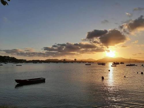 a group of boats on the water at sunset at Suite Praia Parque in Penha