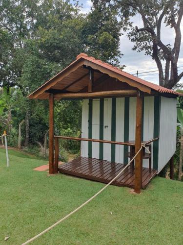 a smallshed with a wooden deck on the grass at Cabana Hostel nas Árvores EcoPark in São Pedro
