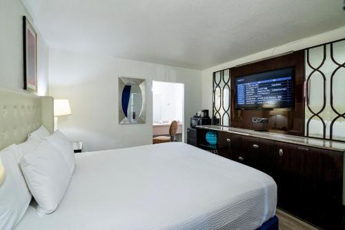 a hotel room with a bed and a flat screen tv at Ramada by Wyndham Yuma in Yuma