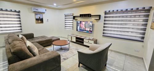 a living room with a couch and a tv at The Leneade in Abuja