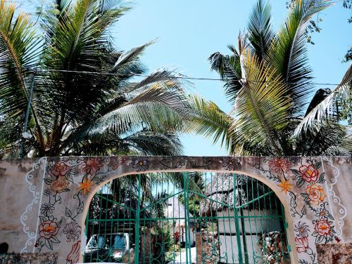an archway with palm trees in front of a building at Hotel y Museo Aldea Maya Toktli Orígenes - Casa Maya Del Toloque Coronado - Alberca, Wifi Starlink, Tour Museo in Izamal