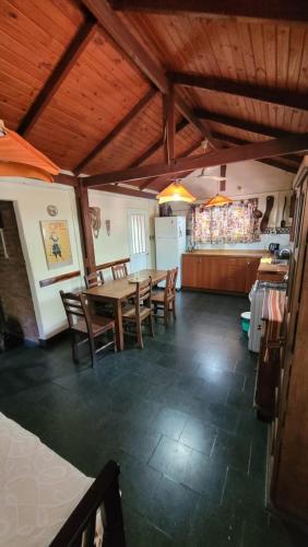 comedor con mesa y sillas y cocina en Hakuna Matata en Santa Rosa de Calamuchita