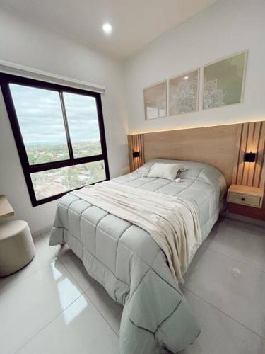 a bedroom with a large bed and a large window at Acogedor departamento! in Luque