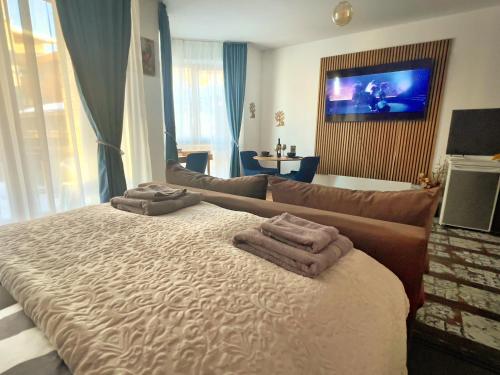 a bedroom with a large bed with towels on it at Blue Apartment Pirin Golf & Spa in Bansko