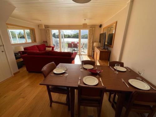 a living room with a wooden table with chairs and a dining room at The Cotswolds Lakeside - Kinsale Lodge,Spring Lake in South Cerney