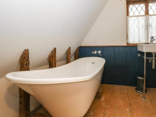 a large white bath tub in a bathroom at 1 Fountain Cottages in Tarporley