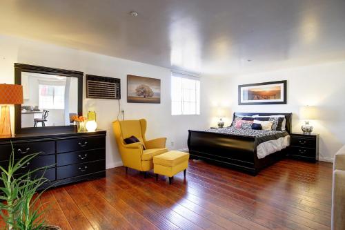 1 dormitorio con 1 cama y 1 silla amarilla en Wine Country Ranch Escape, en Buellton