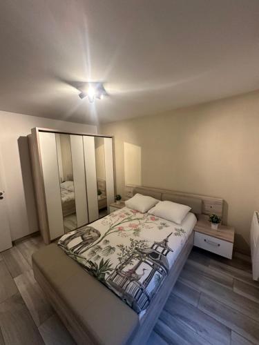 1 dormitorio con 1 cama grande y espejo en Appartement proche Paris et Disney land., en Rosny-sous-Bois