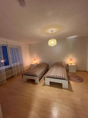 2 Betten in einem Zimmer mit zwei Lampen in der Unterkunft Ruhige Ferienwohnung im Saarland in Schiffweiler