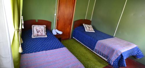 Un dormitorio con dos camas en una habitación. en CAMPING LOS ÑIRES, en Villa Cerro Castillo