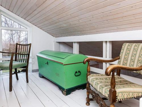 a green trunk sitting next to two chairs on a porch at 6 person holiday home in Karrebæksminde-By Traum in Karrebæksminde