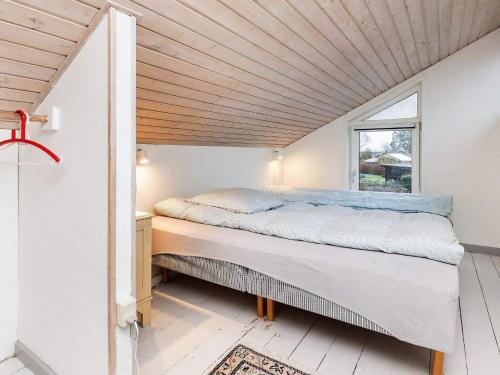 Bett in einem Zimmer mit Holzdecke in der Unterkunft Holiday home Karrebæksminde XXXIX in Karrebæksminde