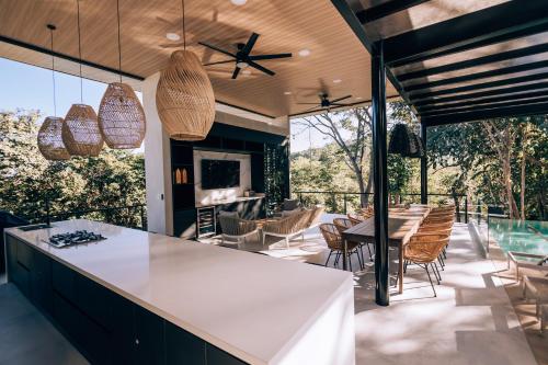 cocina abierta y zona de comedor con mesa y sillas en Epic Tamarindo Boutique Hotel en Villarreal