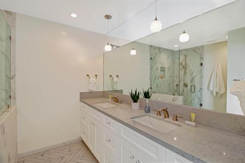 uma casa de banho com 2 lavatórios e um espelho grande em Leadbetter Beach Retreat em Santa Bárbara