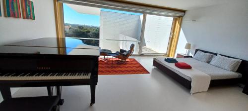 a living room with a piano and a couch at Casa dos Pátios in Sagres