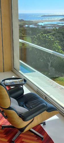 a chair sitting in front of a large window at Casa dos Pátios in Sagres