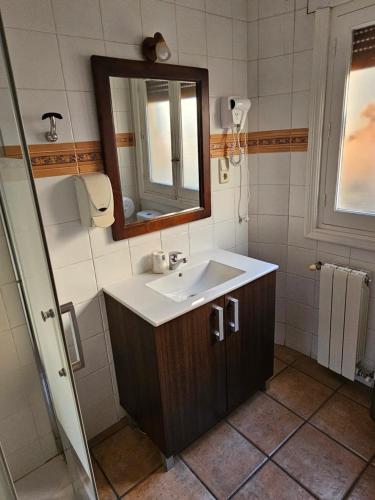 bagno con lavandino e specchio di Hostal La Campana a Toledo