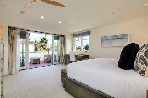 een slaapkamer met een groot wit bed en glazen schuifdeuren bij Casa Playa in Santa Barbara
