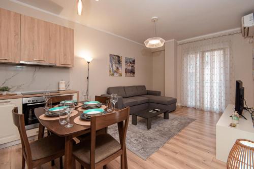 cocina y sala de estar con mesa y sofá en Loris Apartaments 205 en Durrës