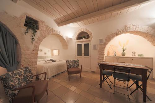 Cette chambre comprend un lit, une table et des chaises. dans l'établissement Trullo Artemis, à Alberobello