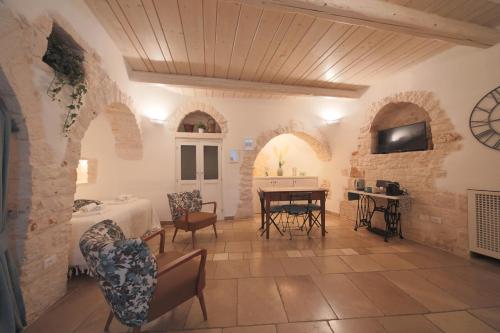 - un salon avec une table, des chaises et une télévision dans l'établissement Trullo Artemis, à Alberobello