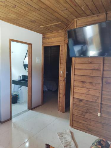 a living room with a flat screen tv on the wall at Pereira Sell Pousada in Garopaba