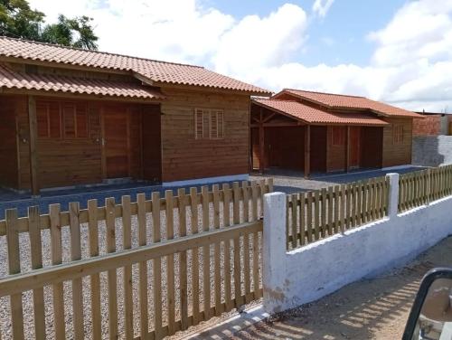 a wooden fence in front of a house at Pereira Sell Pousada in Garopaba
