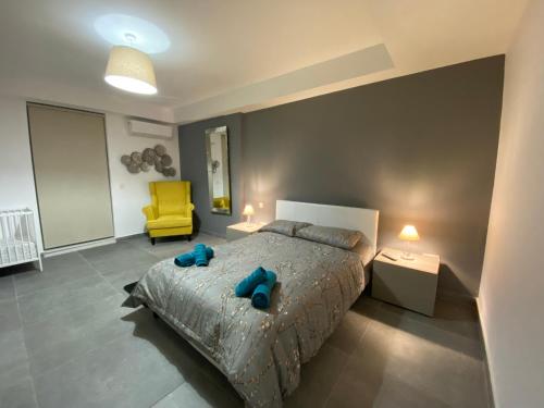 ein Schlafzimmer mit einem Bett und einem gelben Stuhl in der Unterkunft Sliema Seaview & seafront- APT 9, 49 Tigne Point Mansions in Sliema
