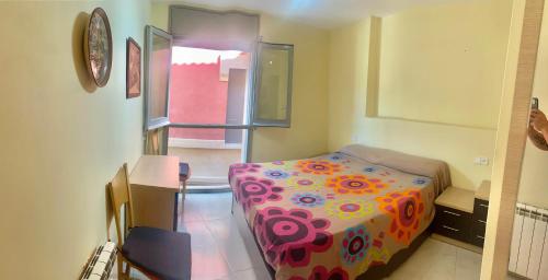 1 dormitorio con 1 cama con un edredón colorido en Aroa s Lake, en Banyoles