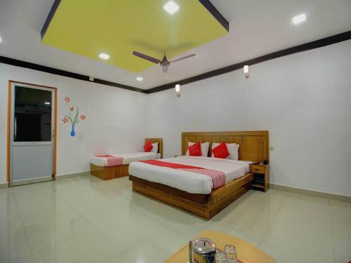 a bedroom with two beds and a table in it at OYO Flagship Ananda Inn in Madurai