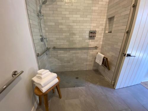 a bathroom with a shower with white towels on a stool at Villa Castillo 3 in Santa Barbara
