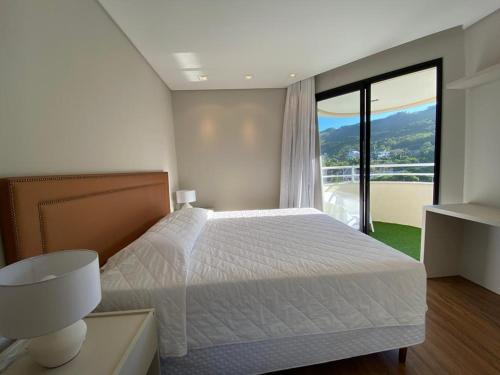 um quarto com uma cama e uma grande janela em Quarto do Praia Brava Hotel em Florianópolis