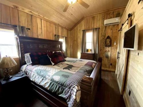 a bedroom with a bed in a room with wooden walls at Couple Retreat Cabin-near Smoky Mountain Railroad-Hot Tub in Bryson City