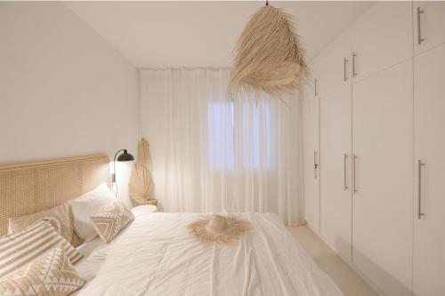 a bedroom with a bed with white walls and a window at Coco Calpe in Calpe