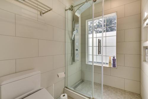 a bathroom with a shower and a toilet and a window at Lake Oswego Home with Deck 9 Mi to Downtown Portland in Lake Oswego